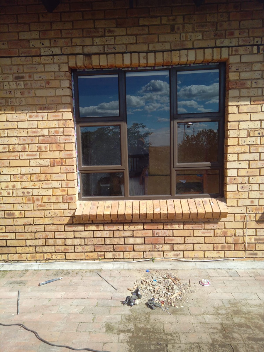 charcoal aluminium window frame on face brick with brick sill