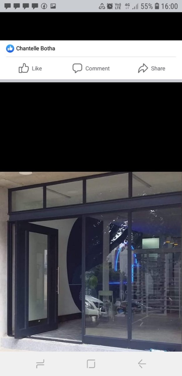 commercial shopfront entry with charcoal aluminium pivot door