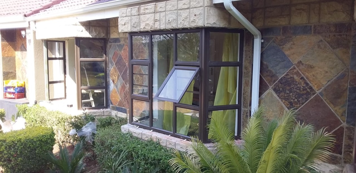 architectural glazing installation on stone-clad home at golden hour