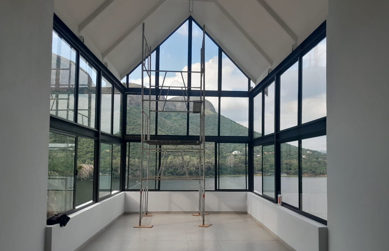 double-height gable glazing in charcoal aluminium overlooking a lake and mountain