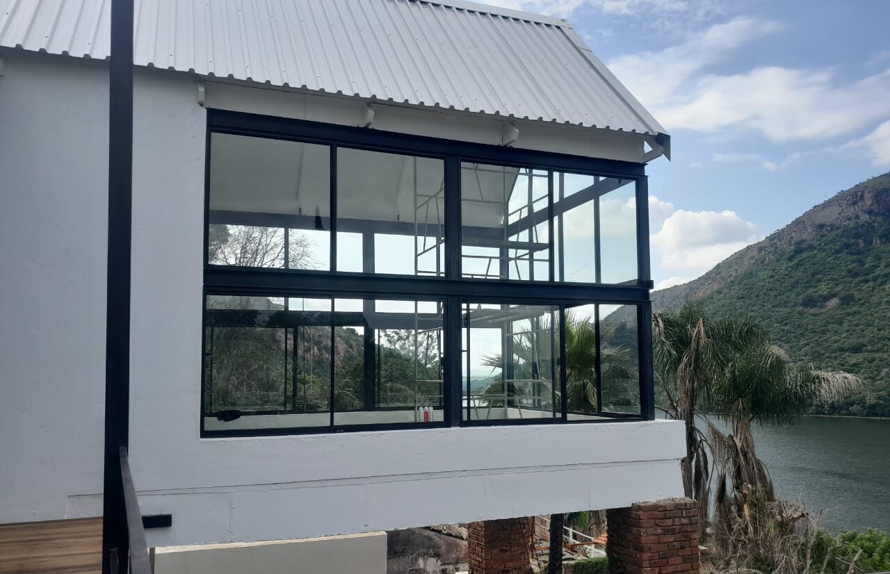 two-storey charcoal aluminium glazed facade on a lakeside home