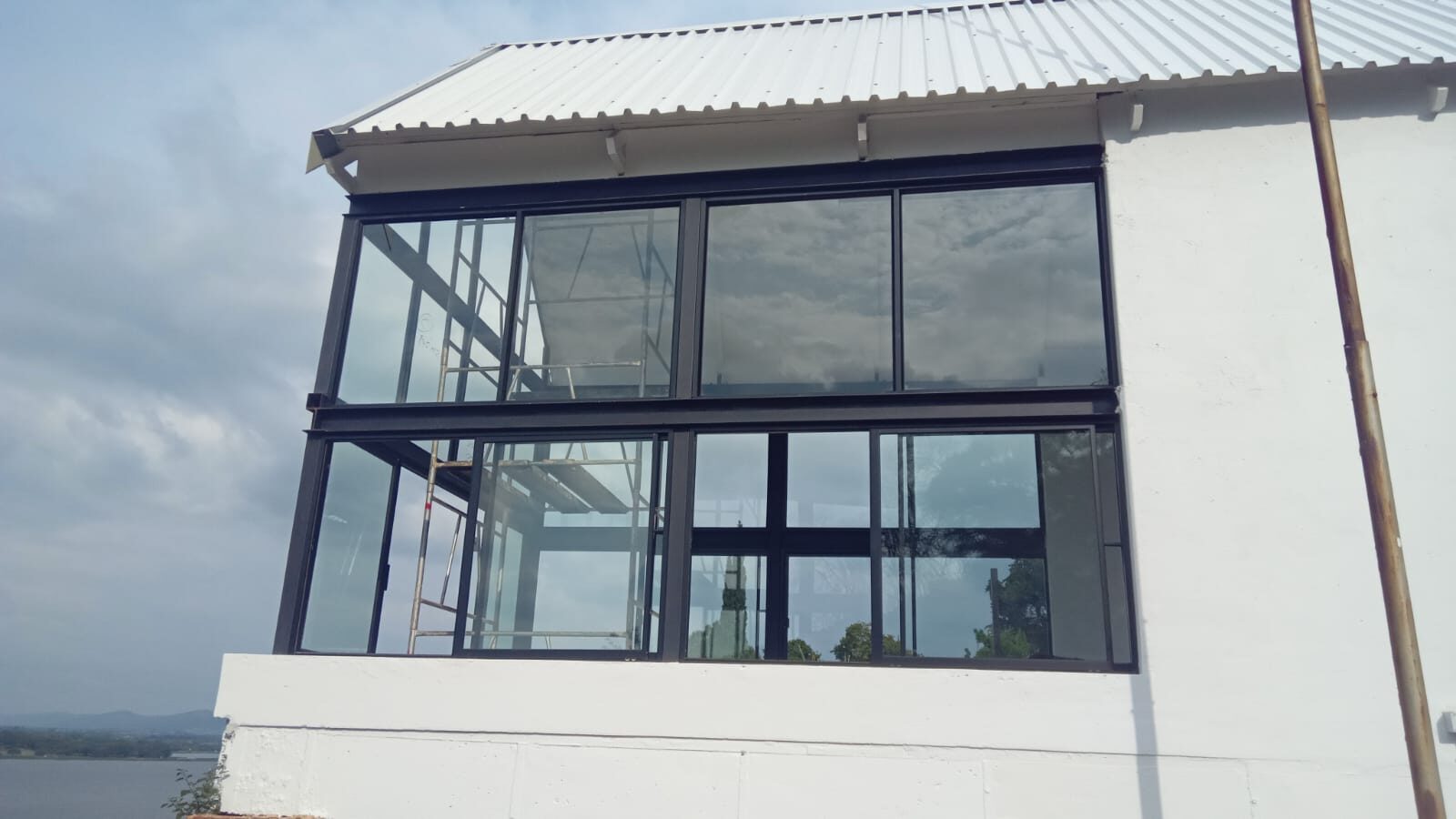 charcoal aluminium glazed gable on a white rendered lakeside home