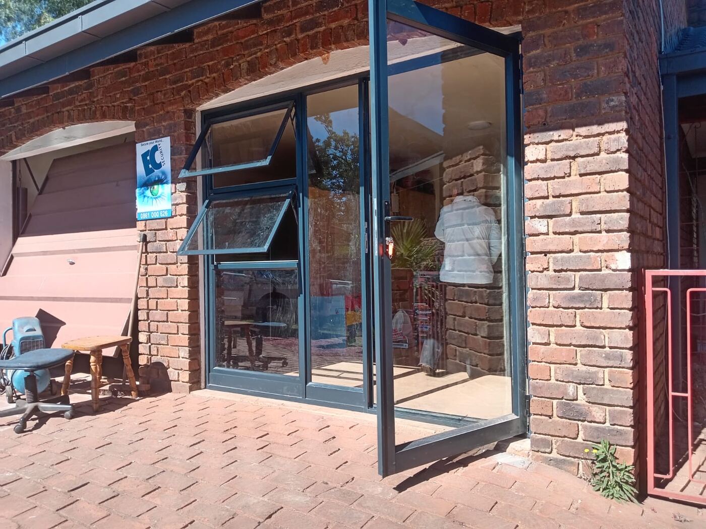 charcoal aluminium entrance door with top-hung awning windows on face brick